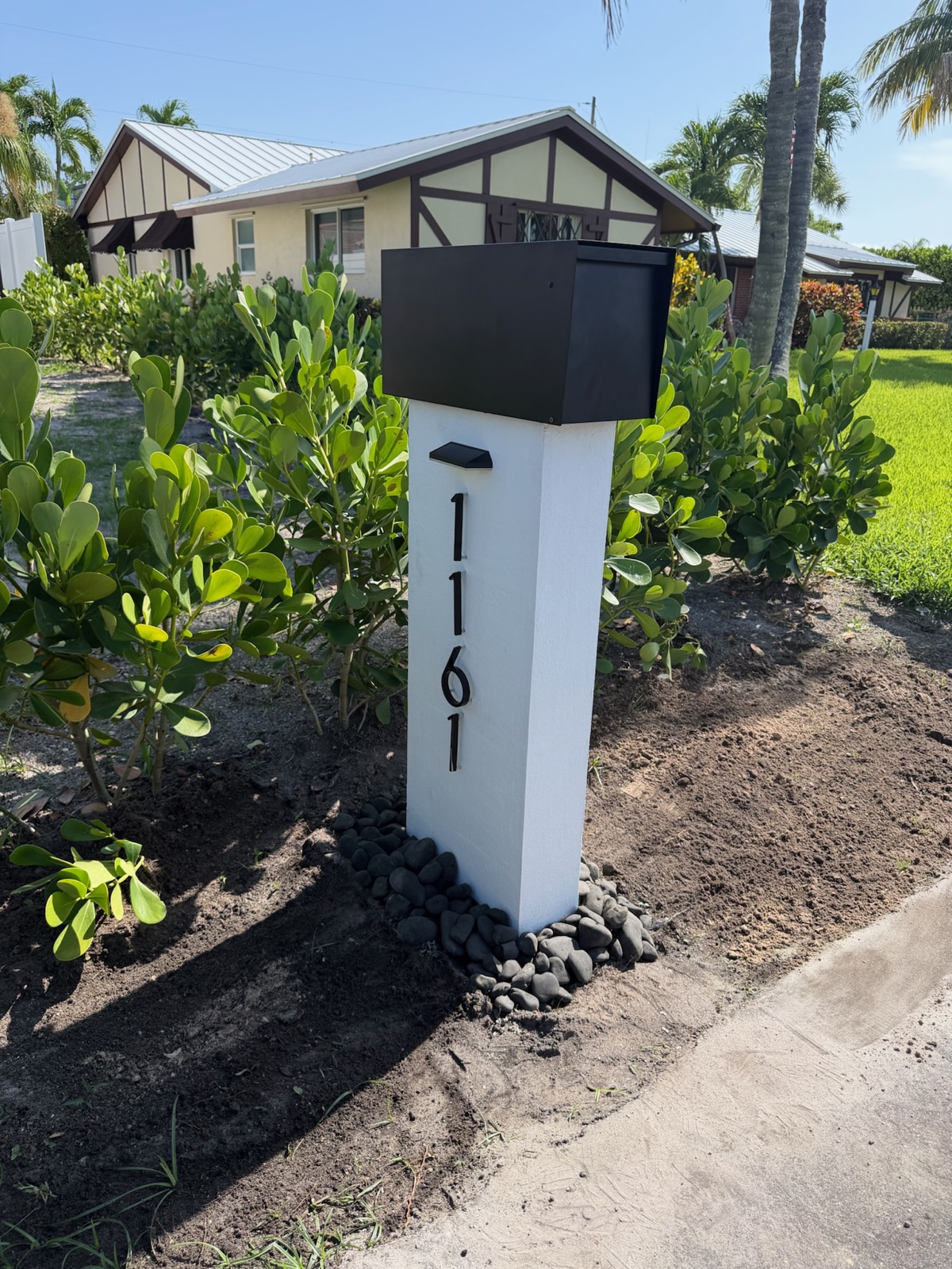 A custom mailbox and post set at the curb of a new Florida home, matched to the exterior color scheme