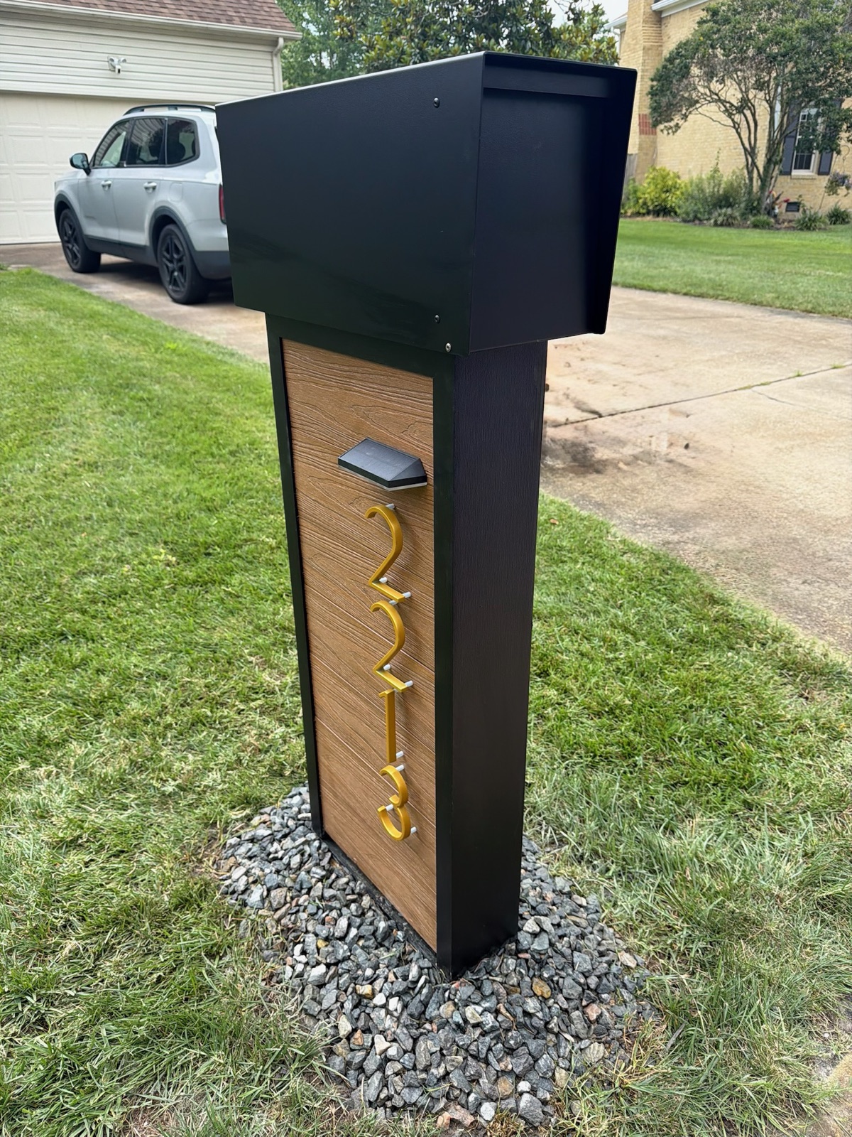 A custom mailbox and post at the curb of a South Florida community home, photographed straight on from the street