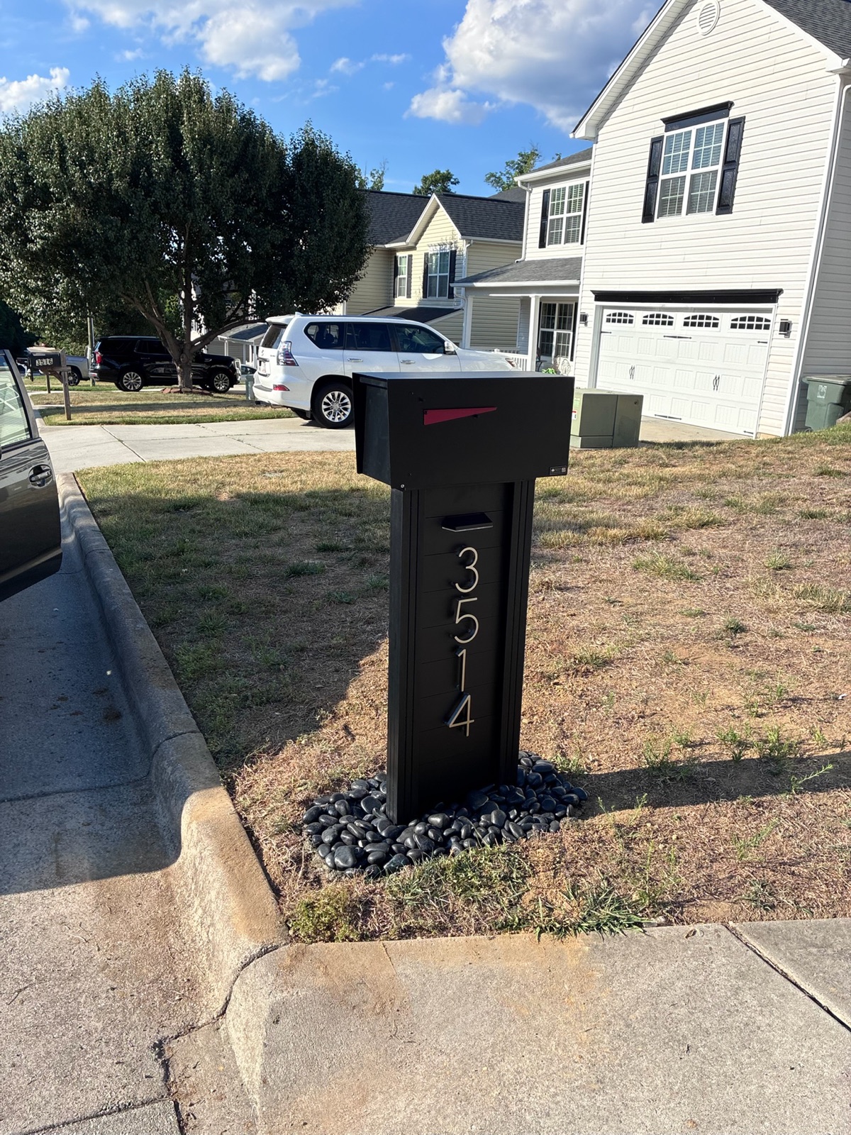 A community mailbox and post documented straight on from the street for a condition record