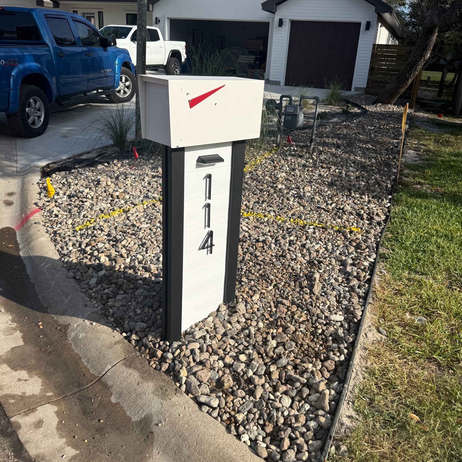 Custom community mailbox and post at the curb of a coastal residential street