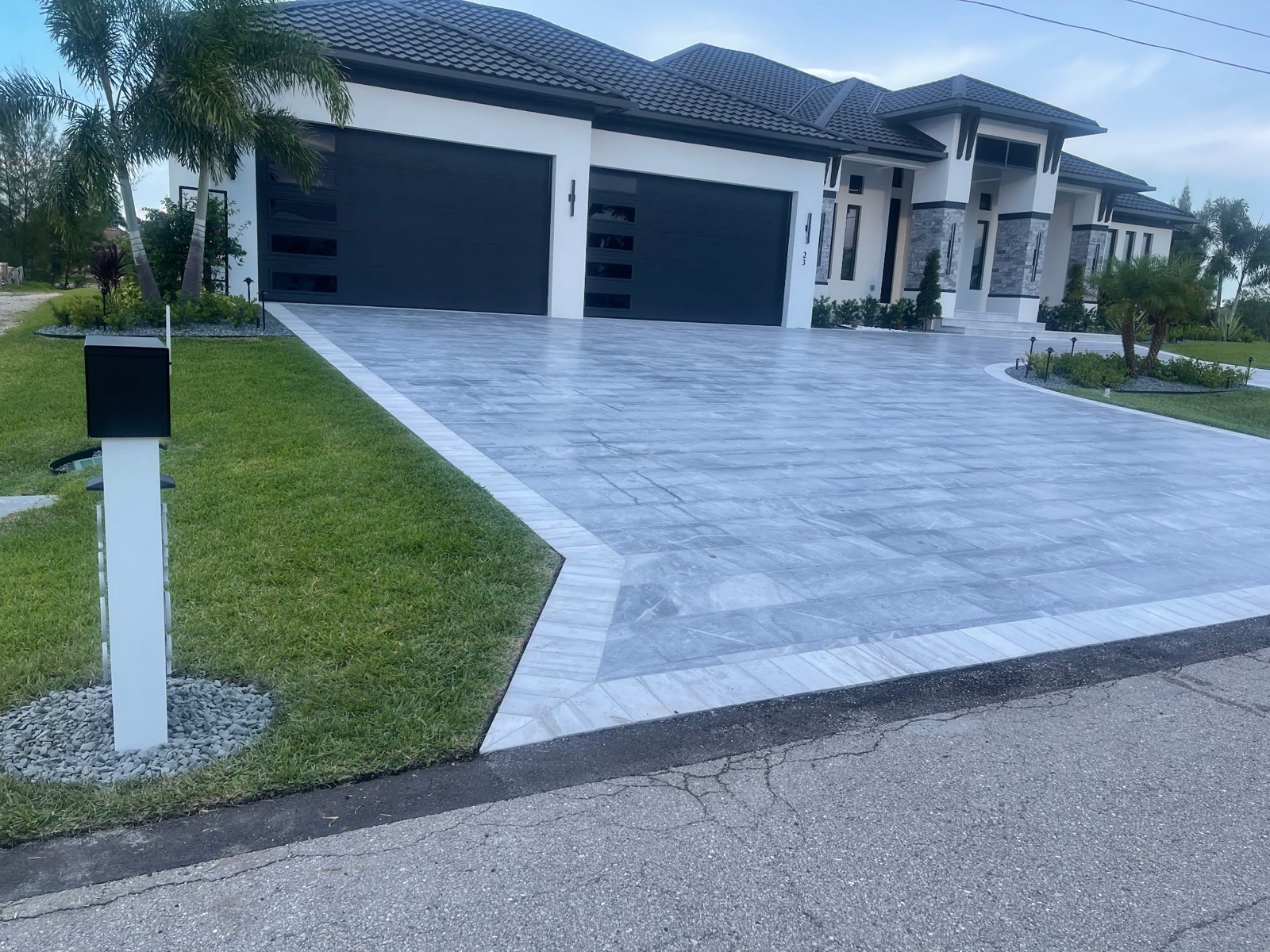 A custom mailbox and post installed at the curb with a finished rock bed at the base