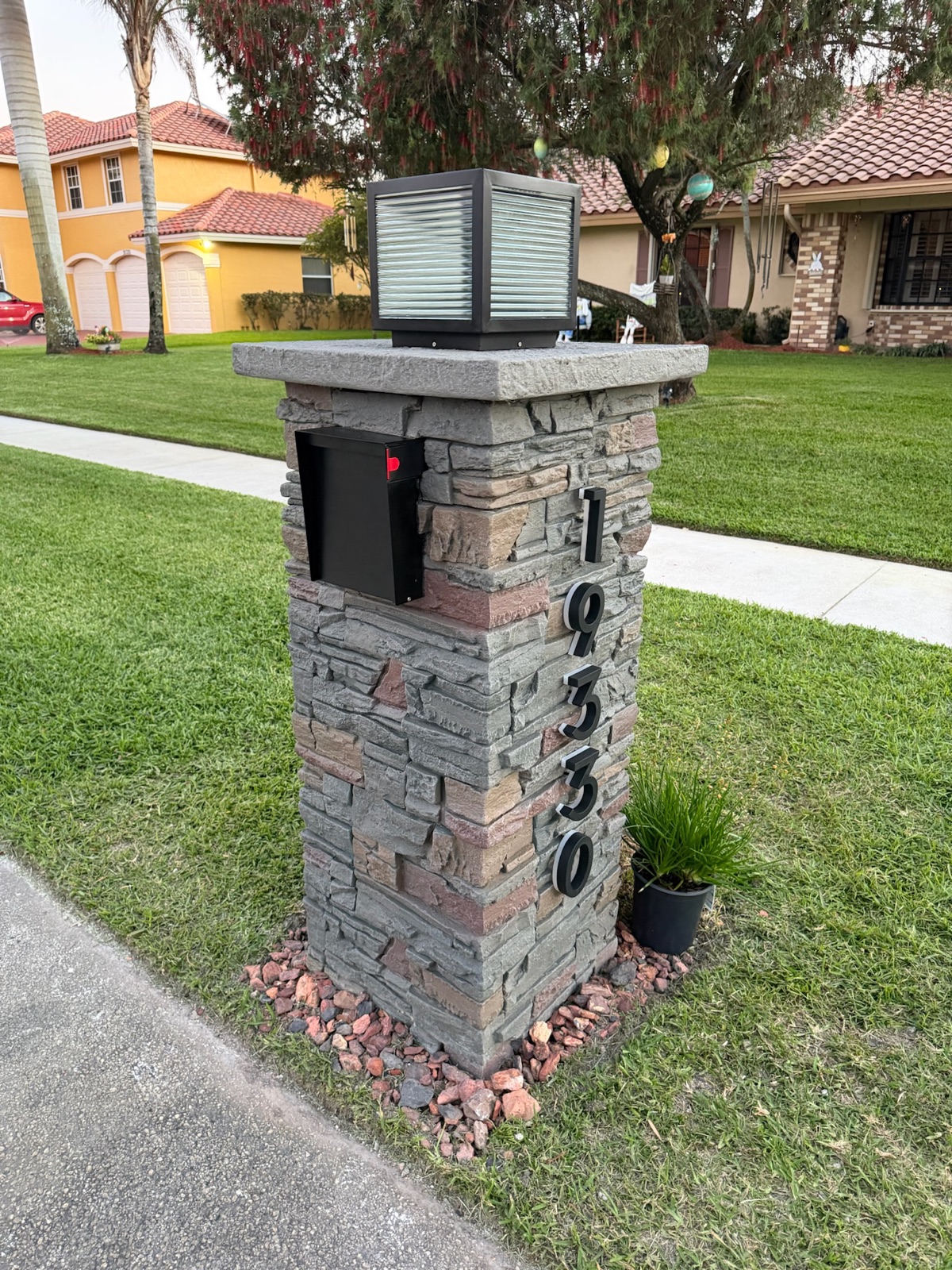 A row of matching custom mailboxes along a community street after a full replacement program