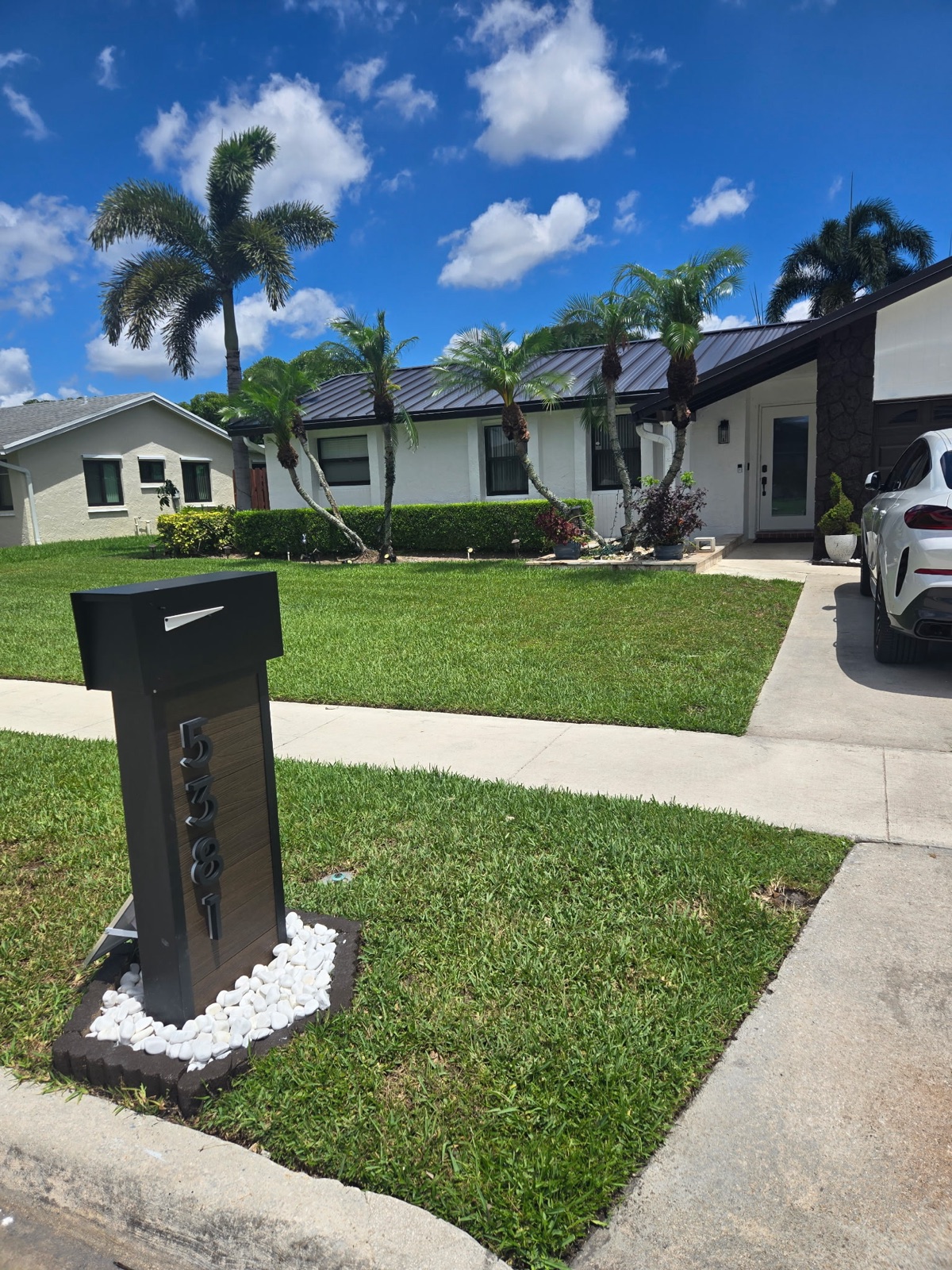 A custom mailbox and post being set at the curb during a phased community installation