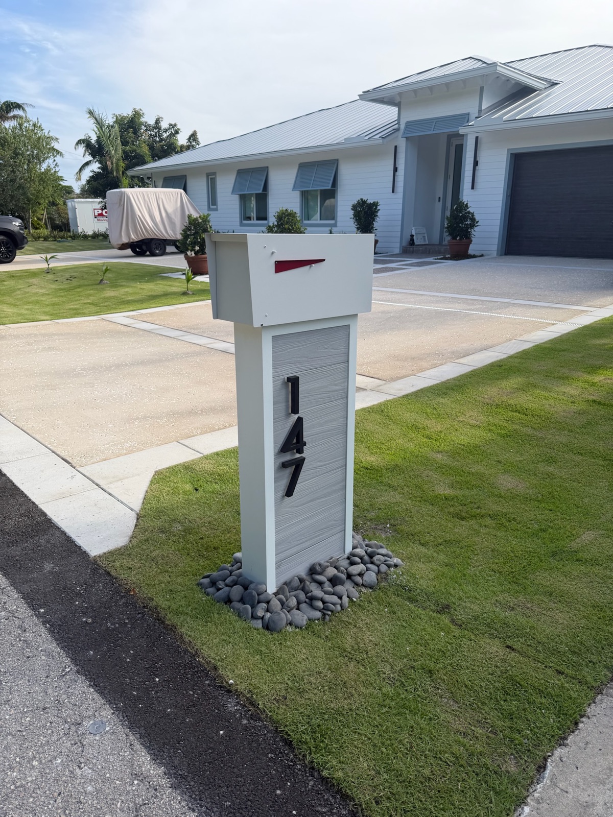 A row of matching custom mailboxes along a residential street in a South Florida community