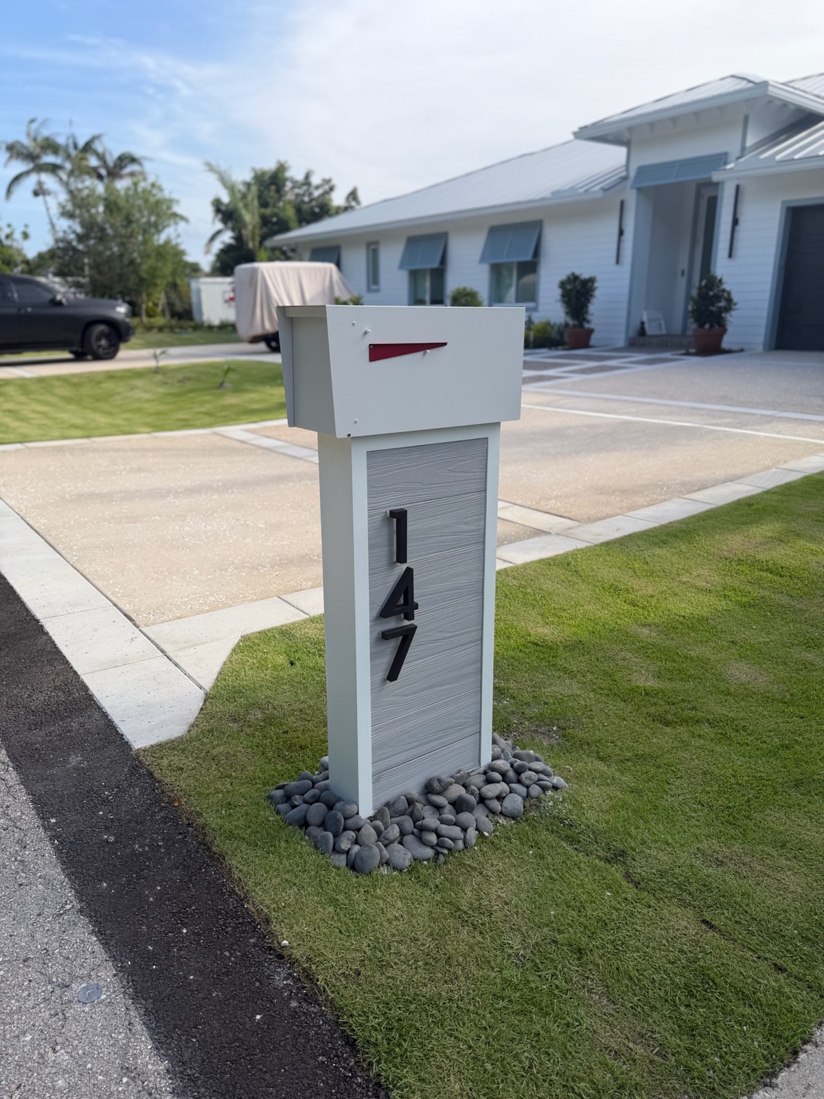 A design mockup of a custom community mailbox with matching post and street numbers