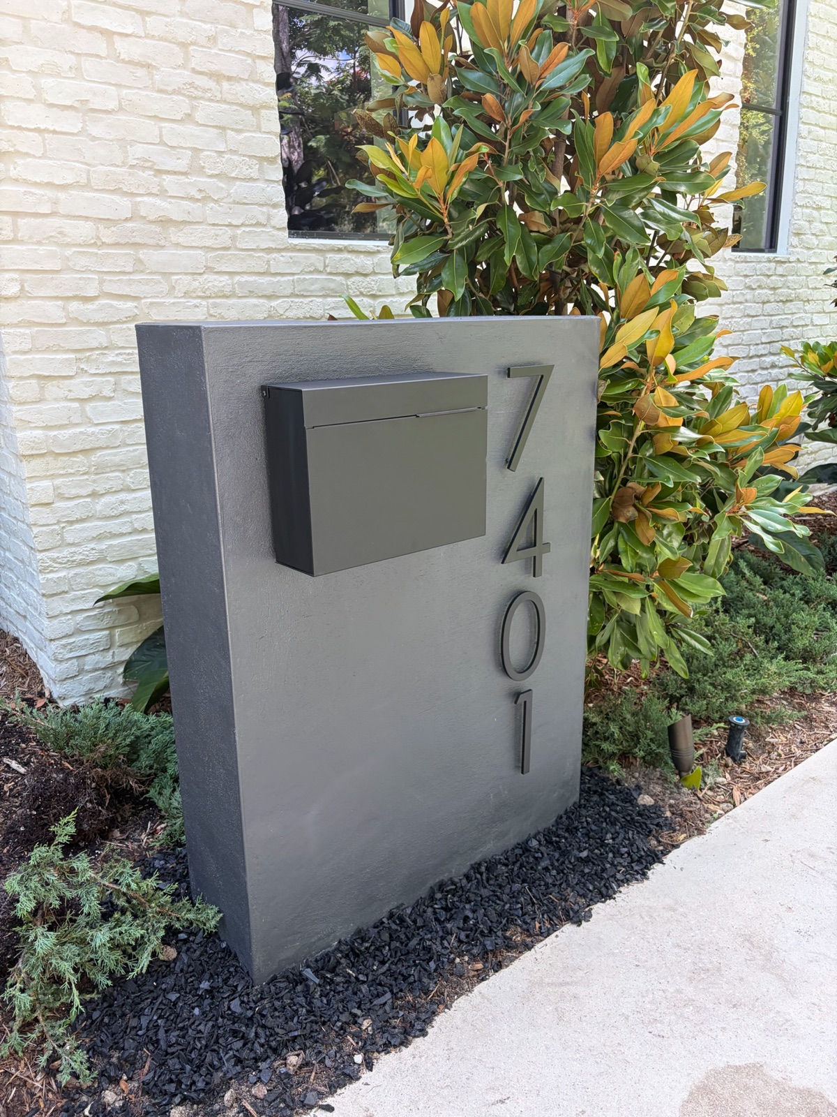 A row of matching custom mailboxes along a community street