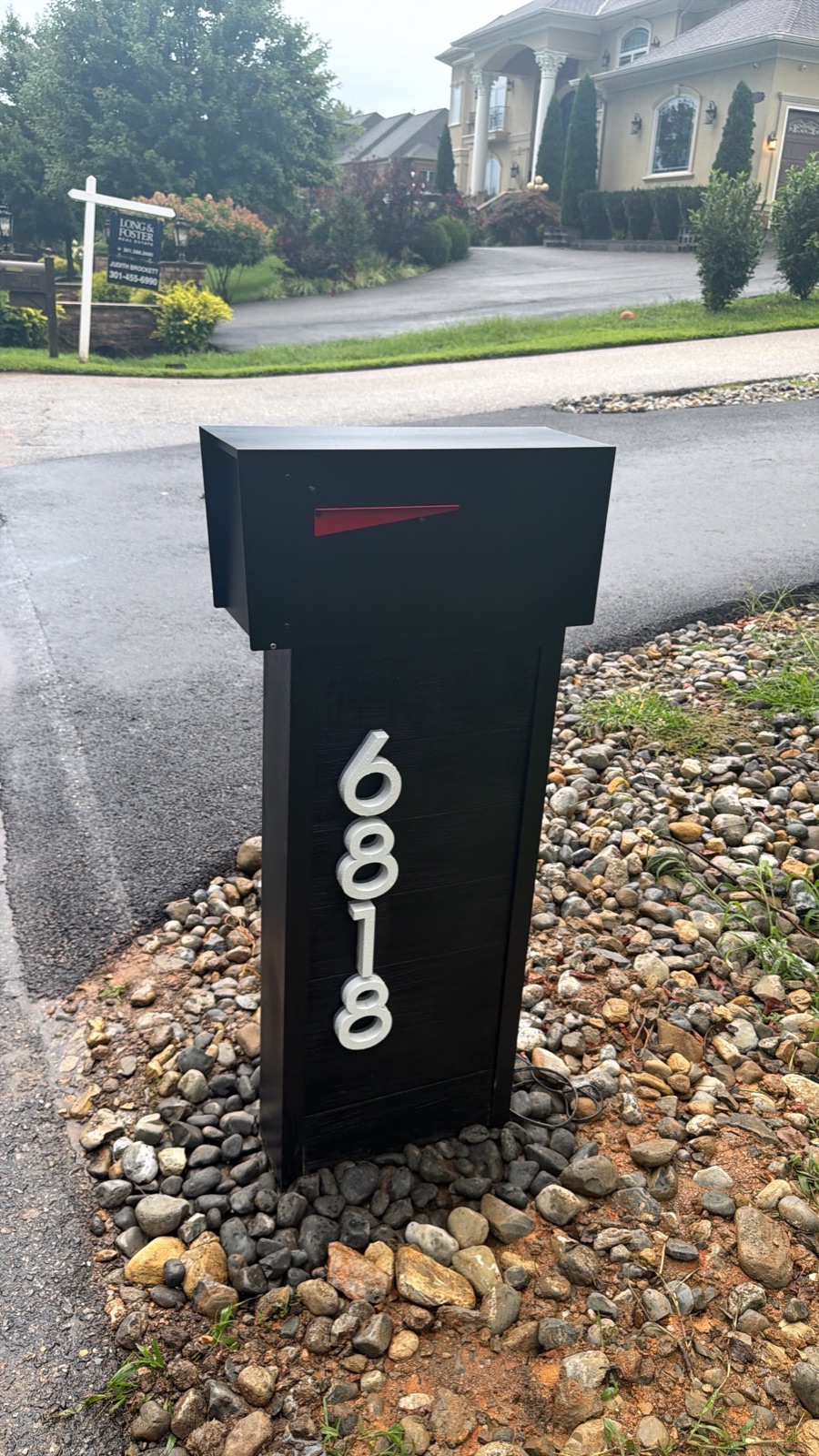 A row of matching custom mailboxes along a community street during a phased replacement