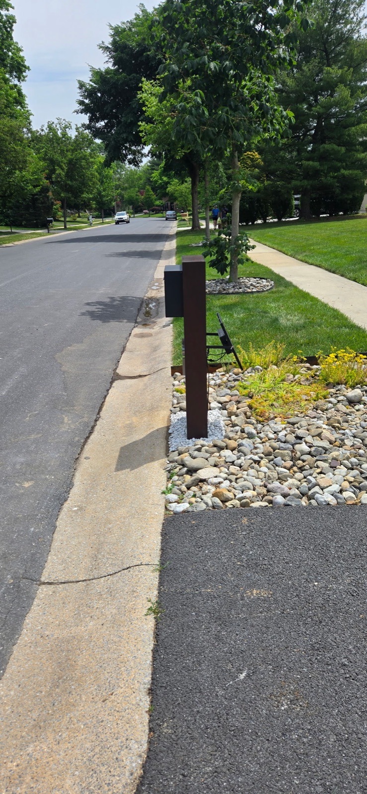 A design mockup of a custom community mailbox shown against a new construction elevation