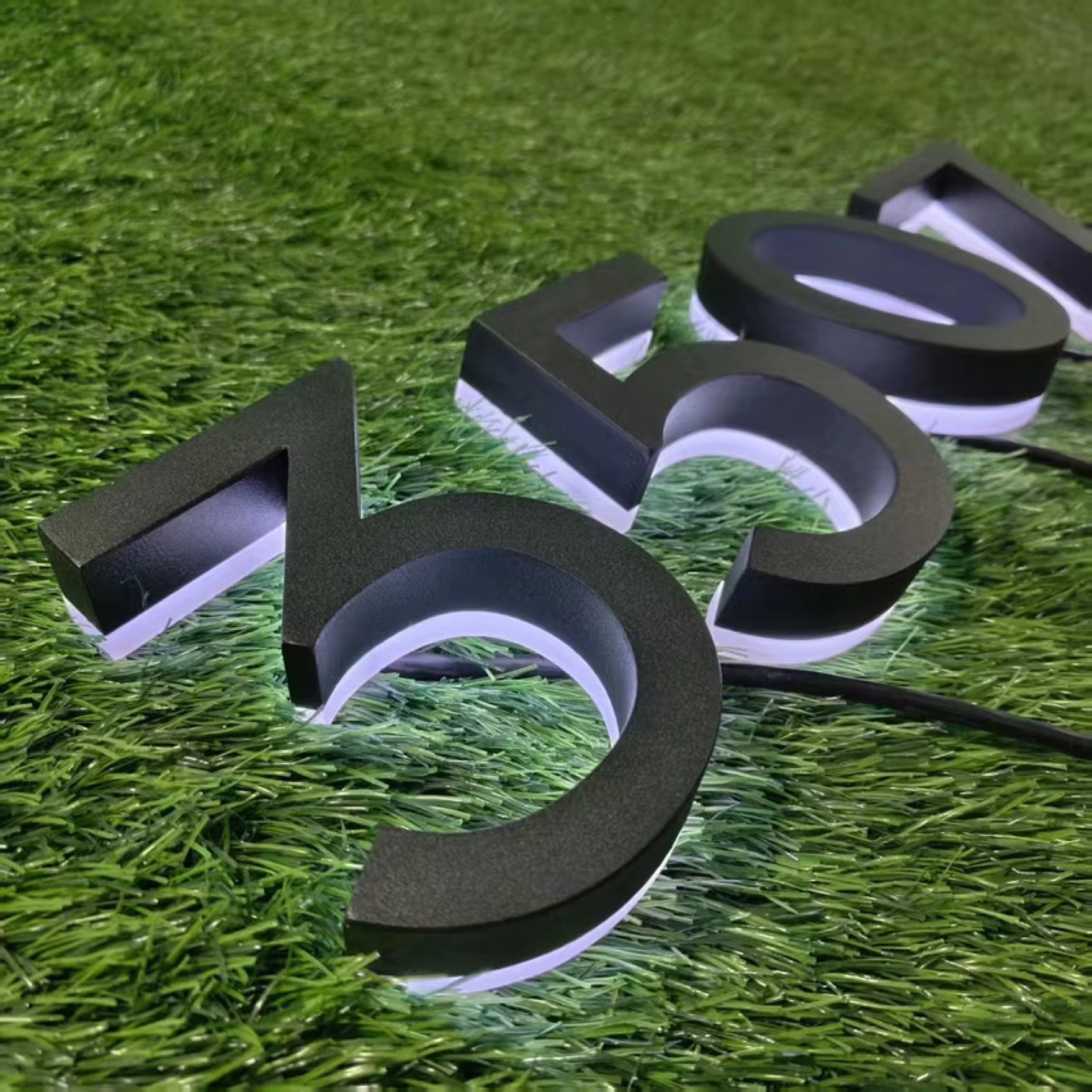 A walnut Slatline mailbox with softly backlit address numbers glowing at dusk