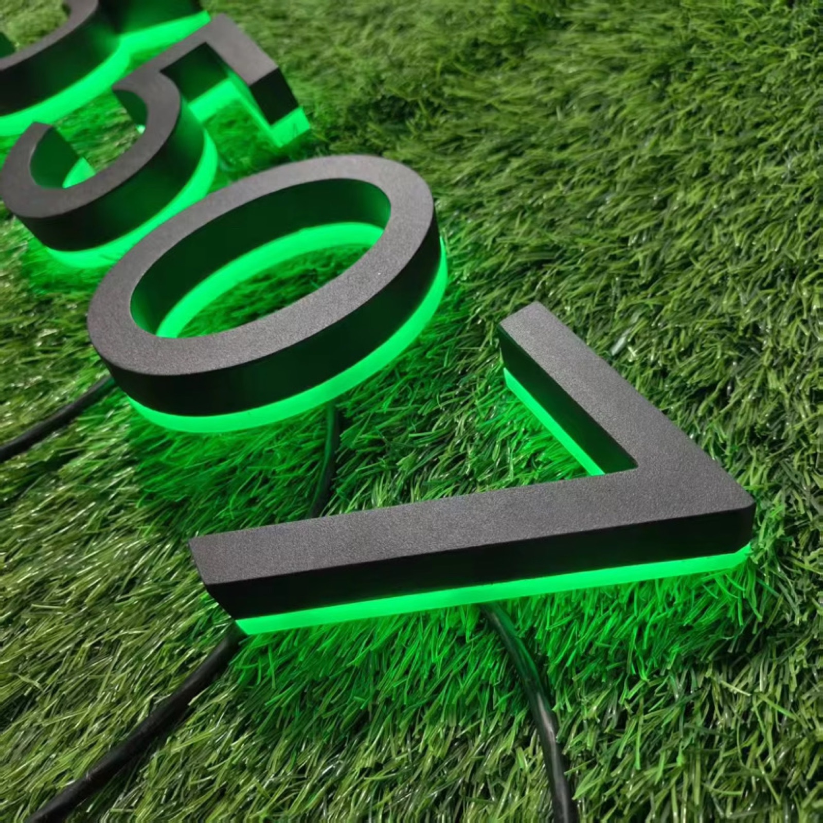 Backlit address numbers glowing on a custom mailbox at night