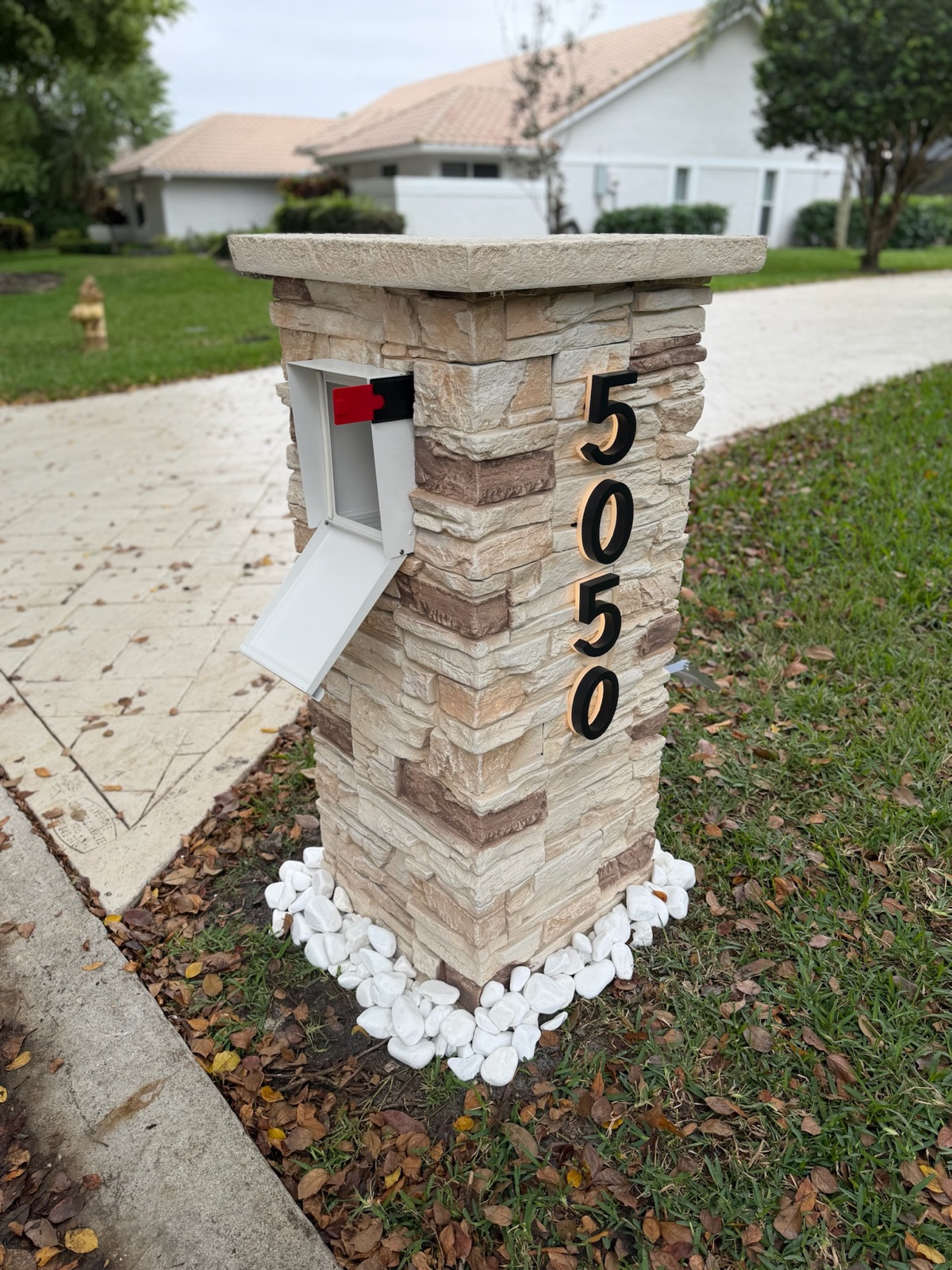 Several faux marble pillar mailboxes shown in different color finishes