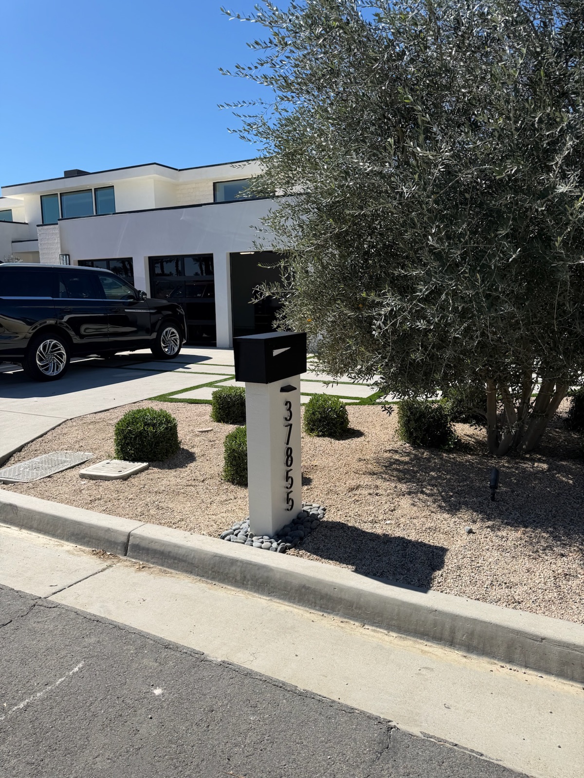 A white Slatline aluminum mailbox set at the curb of a South Florida home
