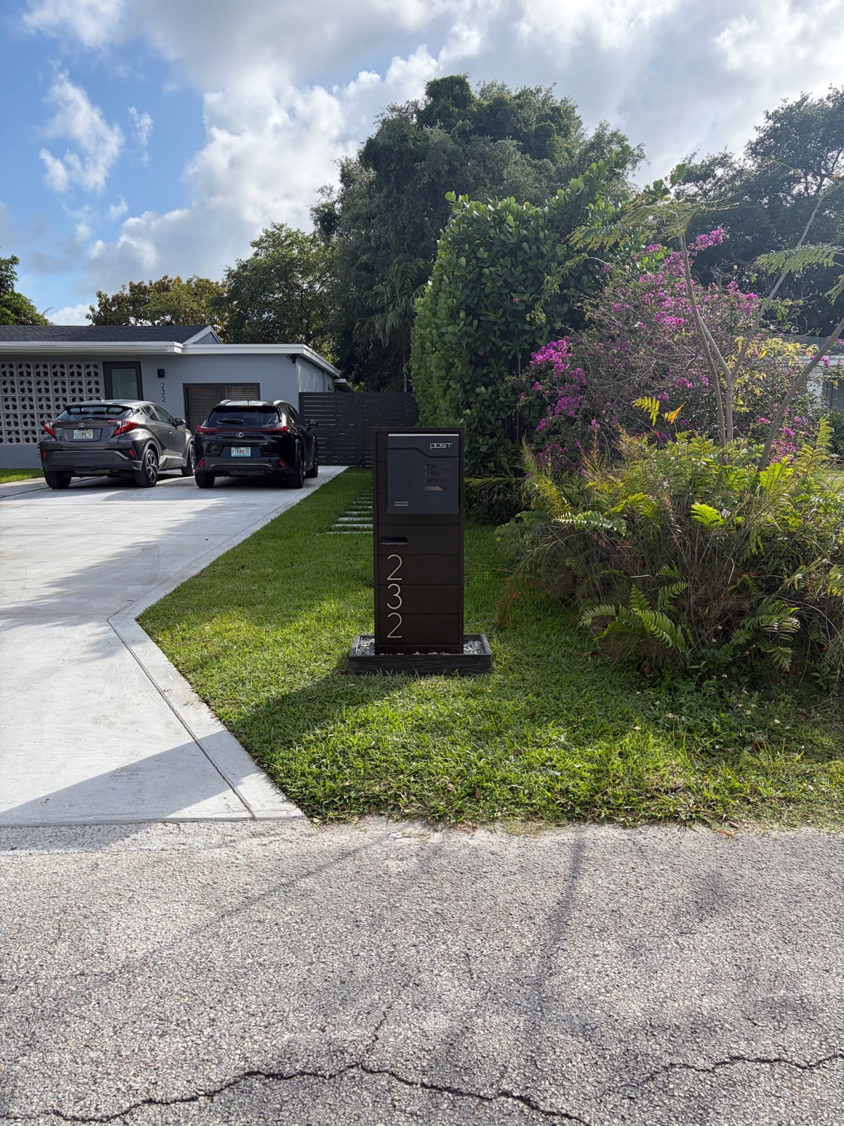 A black Slatline aluminum mailbox set at the curb of a Pacific Northwest home