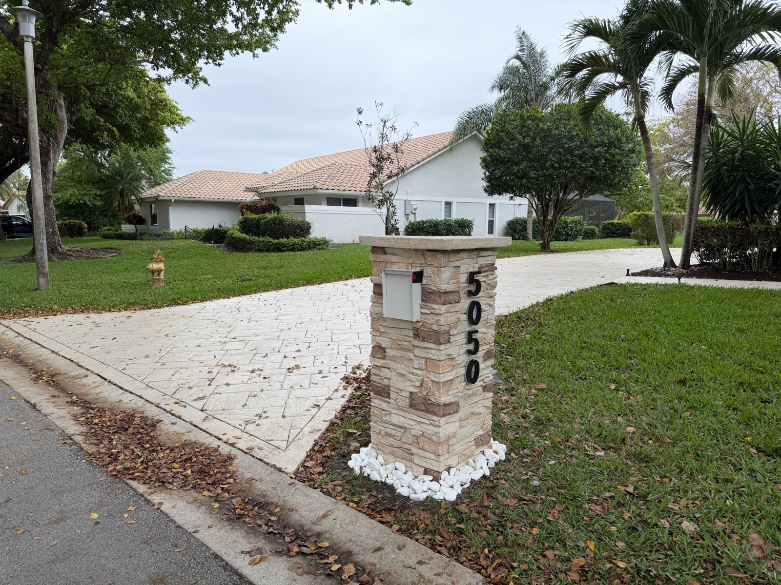 A custom mailbox in a white and walnut finish matched to a subdivision's palette