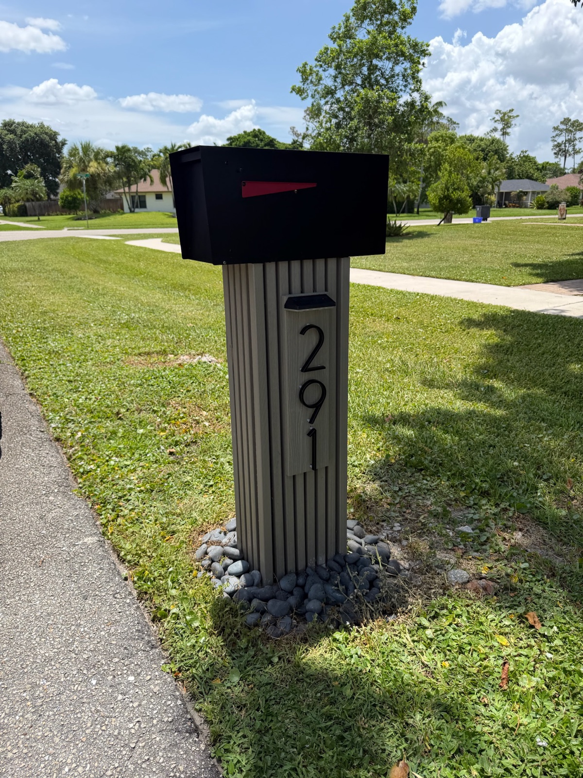 A design mockup of a custom mailbox approved before building, shown next to a suburban Chicago home