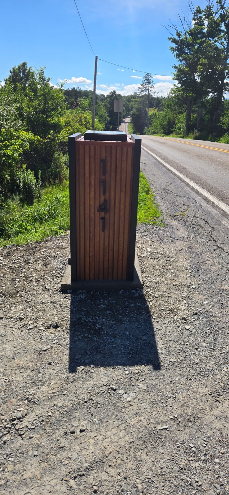 An aging community mailbox post being removed and reset while the existing mailbox is kept