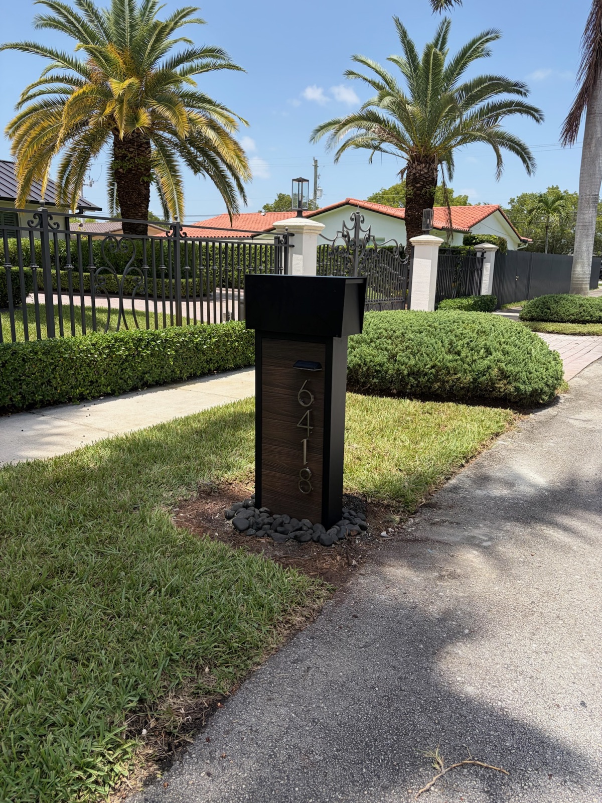 A hand-built custom mailbox made in the USA, set at the curb of a home