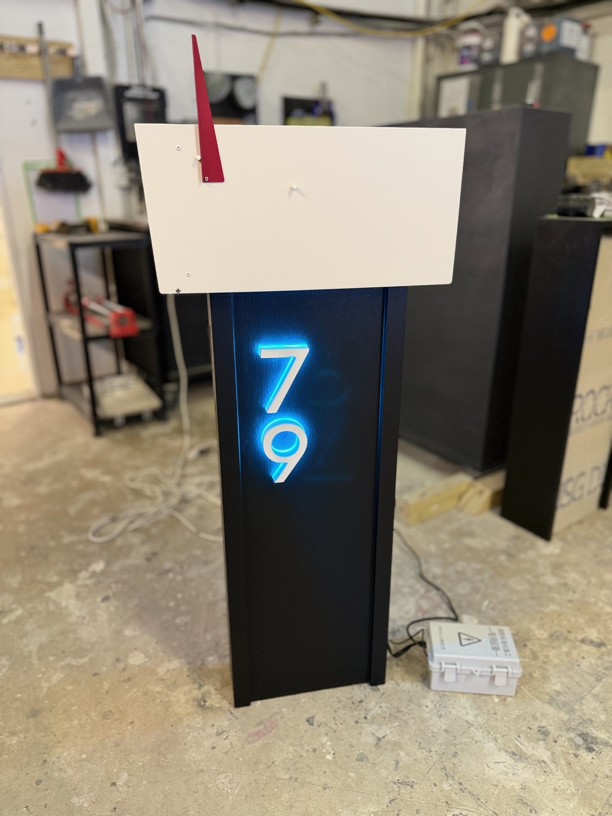 A custom mailbox with illuminated address numbers under assembly in the Dream Mailboxes shop