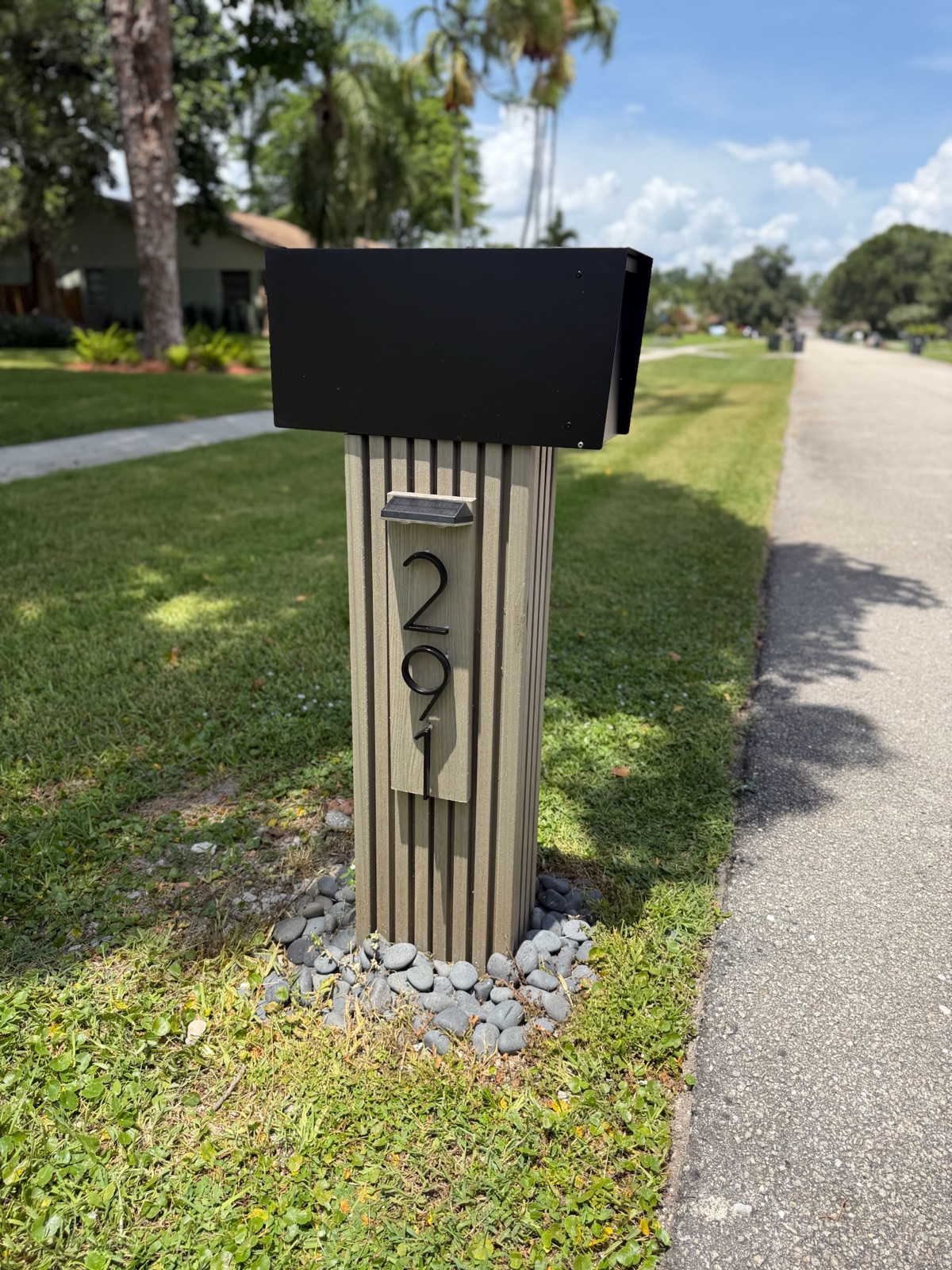 A design mockup of a custom community mailbox with street numbers and matching post